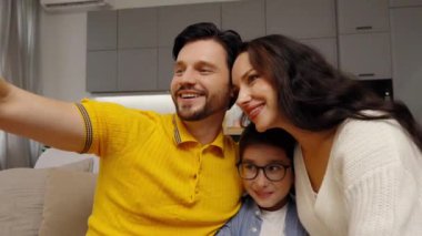 Neşeli bir aile gülümseyerek ve birlikte poz vererek mutlu bir anı yakalar..