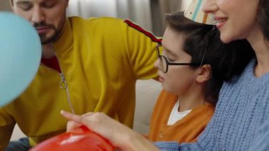 Bir çocuk aile kutlaması sırasında renkli balonlarla oynamaktan hoşlanır..