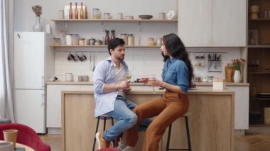 İki arkadaş, şık bir mutfak ortamında içki içip sohbet etmekten zevk alır..