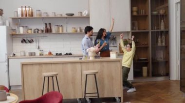 Neşeli bir aile şık mutfaklarında atıştırmalık ve içeceklerden hoşlanır..