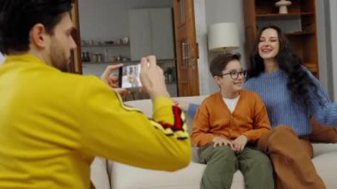 Neşeli bir aile, oturma odalarında birlikte vakit geçirmekten zevk alır..