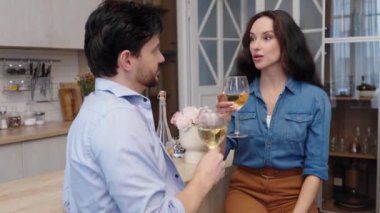 Bir çift, şık mutfak masalarında şarapla kadeh kaldırır..