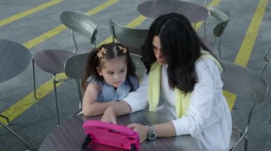 Bir anne kızına tabletteki eğitim içeriğini keşfetmede yardımcı olur..
