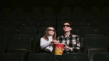 Çiftler sinemada film izlerken eğlenceli bir anı paylaşıyorlar.