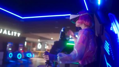 Sanal gerçeklik kulaklığı takan hevesli oyuncu hareketli bir oyun salonunda ilginç bir oyuna girişiyor. Renkli neon ışıklar enerjik atmosferi güçlendirir ve heyecan yaratır..