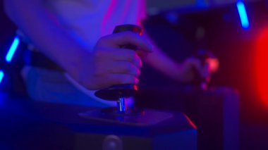 Oyuncular heyecan verici bir oyun salonuna dalarlar, parlak neon ışıkları ve havayı dolduran canlı seslerin arasında gezinirken joystick 'leri sıkıca tutarlar..