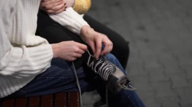 Arkadaşlar eğlenceli bir buz pateni seansına hazırlanmak için birbirlerine yardım ederler..