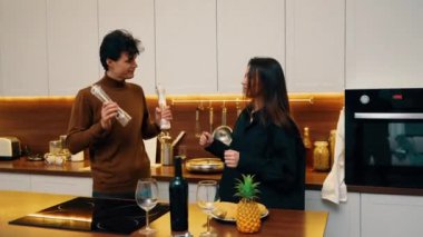 Arkadaşlar birlikte yemek pişiriyor, yemek hazırlarken kahkaha ve keyif paylaşıyorlar..