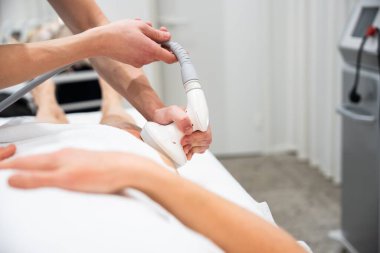 Bir profesyonel, müşteri dinlenirken cilt tedavisi uygular.