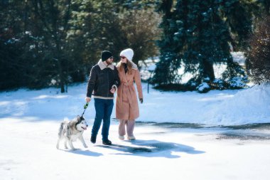 Karlı bir arazide, kabuklarıyla el ele yürüyorlar..