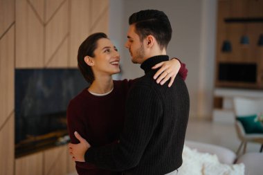 İki insan keyifli bir anı paylaşır rahat, şık bir oturma odasında.