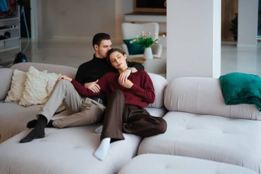 Bir çift rahat bir kanepede rahatlar, kapalı bir yerde mahrem bir anı paylaşırlar..