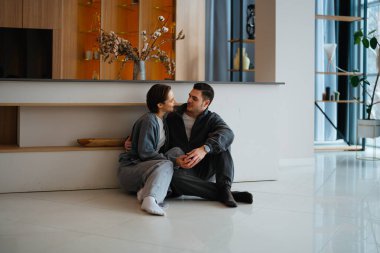 İki insan şık bir kapalı mekan ortamında hassas bir anı paylaşıyor..