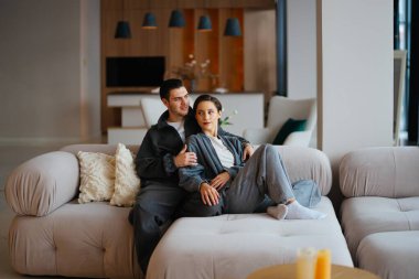 Bir çift şık bir yaşam alanında rahat bir kanepede rahatlar..