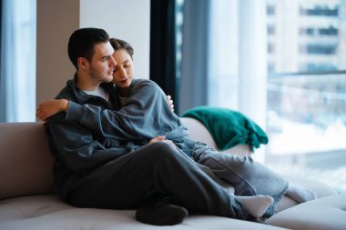 Genç çift şık bir odada kanepede birlikte vakit geçirmekten hoşlanıyor..