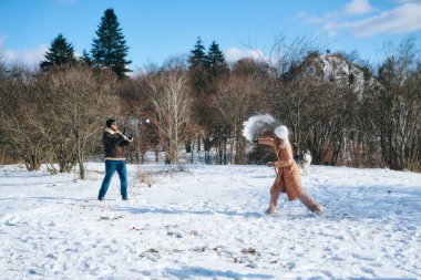 Güneşli bir kış gününde iki arkadaş neşeli bir kartopu kavgasına tutuşur..
