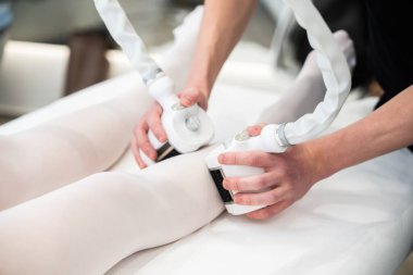 Profesyoneller bacak üzerinde modern teknoloji kullanarak vücut hatları oluşturuyorlar.