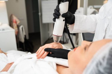 Müşteri, profesyonel bir cihaz operatörüyle kaplıcada cilt bakımı yaptırıyor..