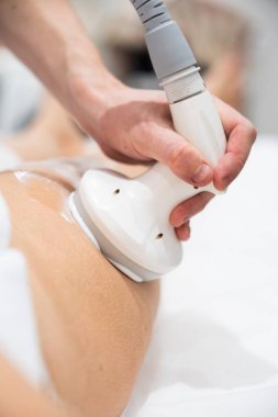 Terapist vücut hatları için hastaların kalçalarına ultrason uygular..