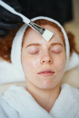 Rahat bir kadın huzurlu bir kaplıca ortamında cilt bakımı yaptırır.