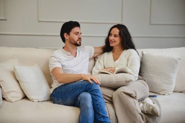 Bir çift, huzurlu bir öğleden sonrayı rahat bir kanepede kitap okuyarak geçirir..