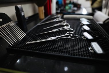 Şık bir salon ortamında düzenlenmiş çeşitli makas ve taraklar.