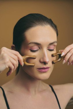 Bireyler rahatlamak ve güzelleşmek için yüzüne ahşap masaj aletleri kullanıyor..