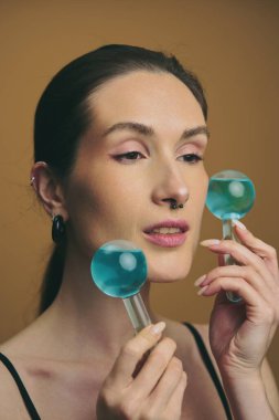 Model evde cilt rutinini geliştirmek için mavi yüz araçları kullanır.