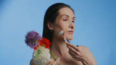 Güzellik silindiri ve taze çiçeklerle yapılan bir cilt gösterimi..