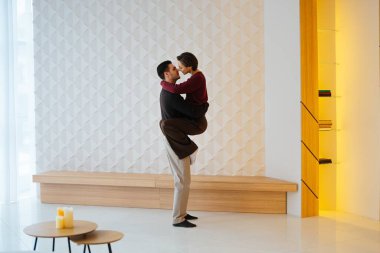 Günışığıyla dolu çağdaş bir ortamda bir çift sevgi dolu bir anı paylaşıyor..