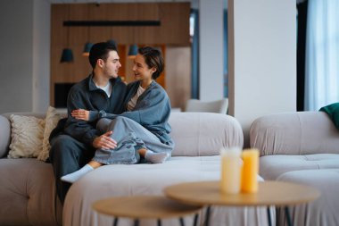 Genç çift uzayda koltukta otururken rahatlamış ve gülümsüyor..