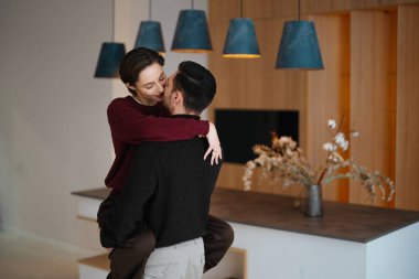 Romantik çift zarif iç dekorasyon ve ışıklandırmayla kucaklaşır.