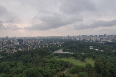 Sao Paulo 'ya bakan, bulutlu gökyüzünün altında şehrin ve doğanın bir karışımı..