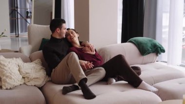 Çift kanepeye yakın oturur, güzel bir yerde gülümsemelerini ve sıcaklıklarını paylaşırlar..
