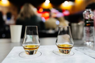 Geceleri arka planda hareketli bir kalabalıkla güzel bir viskinin tadını çıkarıyorum.