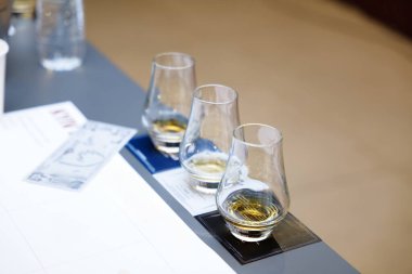 Üç bardak kaliteli viski, bir masanın üstüne nazikçe oturur, tatmaya hazır..