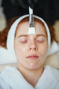 Bir kadın spa 'da rahatlatıcı bir yüz tedavisiyle rahatlamayı sever..