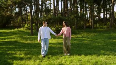 Bir çift gün batımında yemyeşil, yemyeşil bir ormanda huzurlu bir gezinti yapıyor..