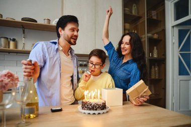 Bir çocuk doğum günü pastasında mumları üflüyor..