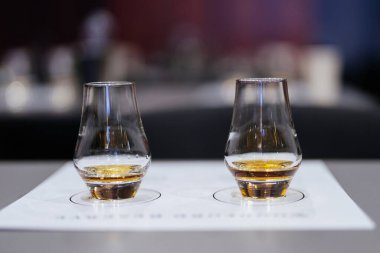 Sıcak bir mekanda tatma etkinliği sırasında iki zarif bardak kehribar viskisi içerir..