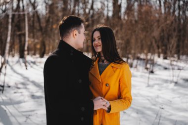 Genç çift, karlı bir arazide bir anlık sevgi paylaşıyor..