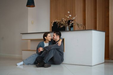 Çağdaş bir mutfakta iki insan sıcak ve samimi bir anı paylaşır..