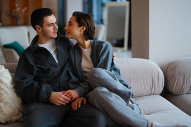 Çift kanepede birlikte oturur, samimi anlar paylaşır..