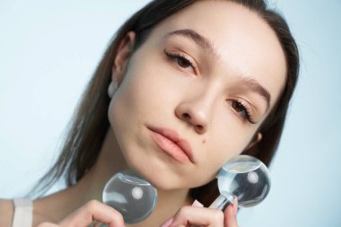 Kadın model, parlak bir stüdyo ortamında cam kürelerle poz veriyor..