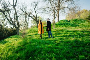 Canlı yeşil bir parkta iki kişi, sıcak bir sohbete girişiyor..