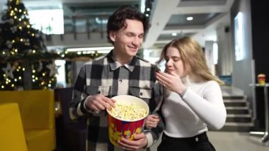 İki arkadaş, festival sezonunu kutlarken patlamış mısırlarını tiyatroda paylaşıyorlar..