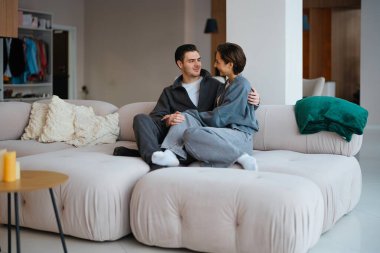 Çift, yumuşak ve ferah bir kanepede rahat bir öğleden sonranın tadını çıkarıyor..