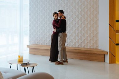 Bir çift, kapalı bir alanda doğal ışıkla yakın dans eder..