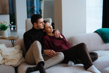 İki birey, sıcak ve davetkar bir ortamda sessiz bir anın tadını çıkarırlar..