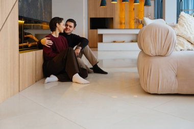 Çift şık bir oturma odasının zemininde otururken sıcak bir anın tadını çıkarıyor..